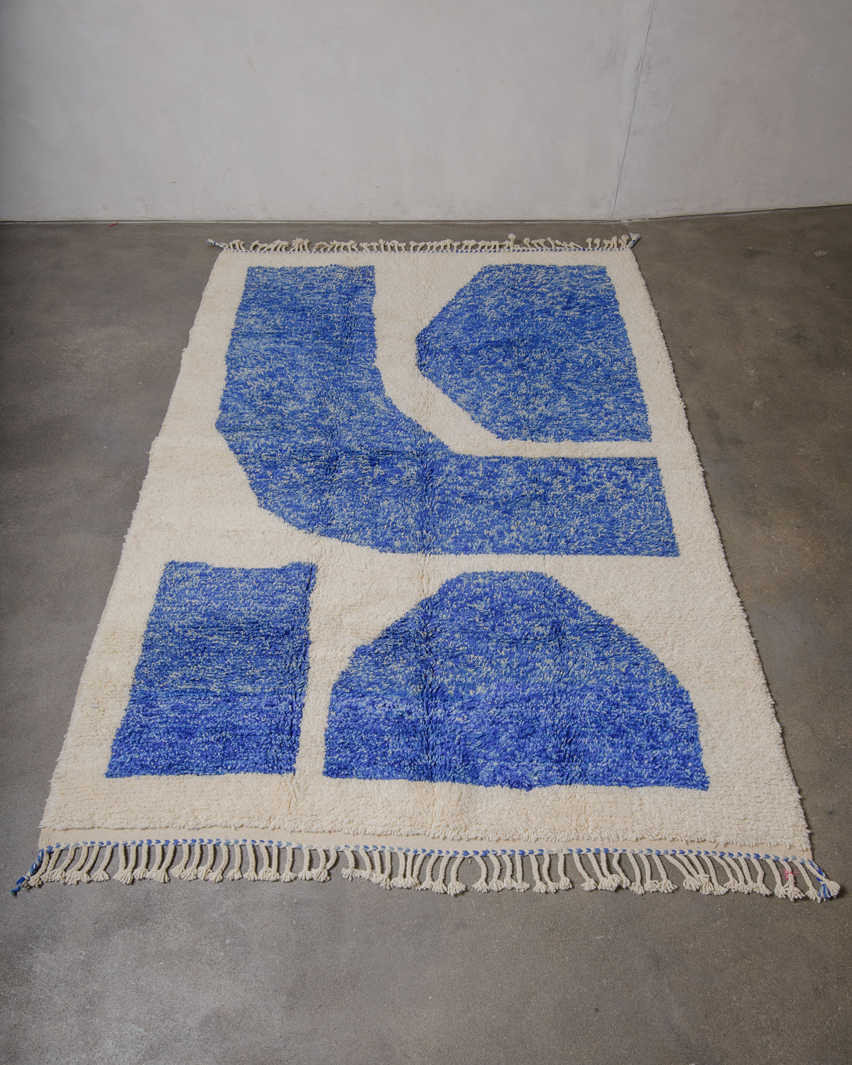Woven rug with blue geometric patterns on a plain background